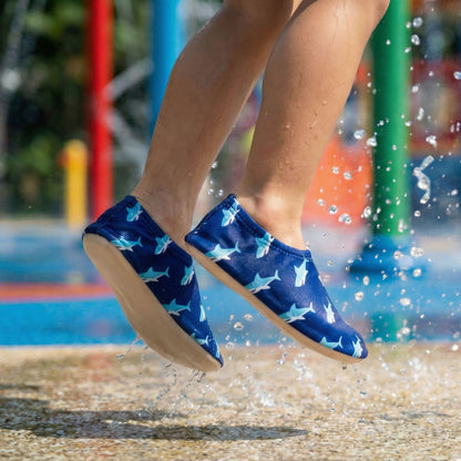 Blue shark-patterned non-slip water socks being worn by a child jumping into water at a Singapore waterpark.